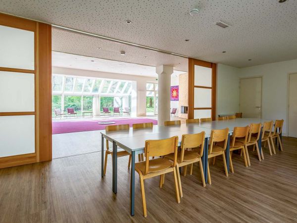 De eetzaal van Gebouw 3 met schuifwanden en uitzicht op de grote zaal met glazen erker