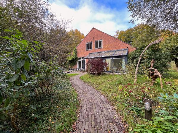De pad naar het Voorhuis met de glazen erker en overkapping.