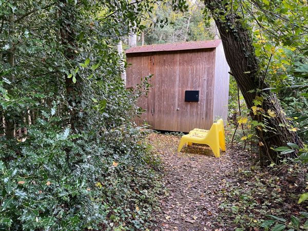 De sauna verscholen tussen de struiken bij het Voorhuis en Gebouw 1.