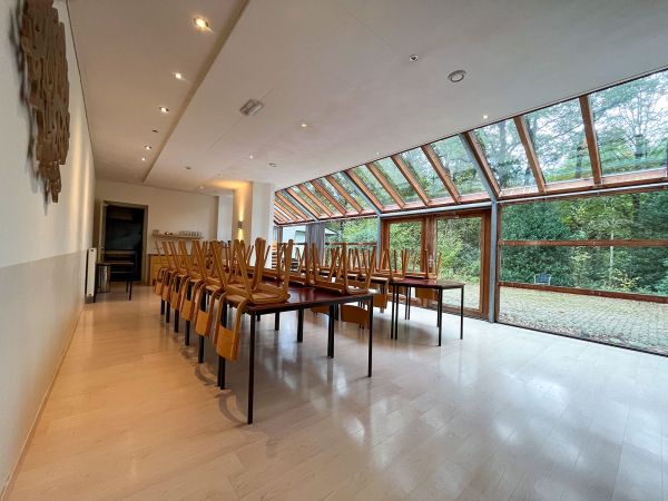 De eetzaal en glazen erker met brede deuren naar het terras.